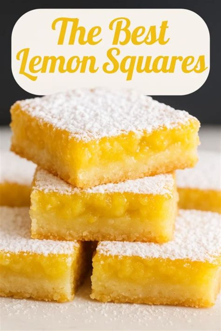 Stack of lemon cake squares on a white plate.