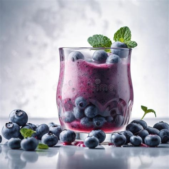 Triangular glass filled with blueberry cheesecake. 